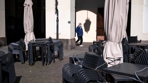 A man walks near a closed bar in Piazza Vittorio in Turin on March 17, 2021.
