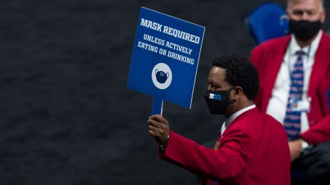An usher holds up a mask-required sign during the men's Big Ten college basketball tournament on March 11 in Indianapolis.