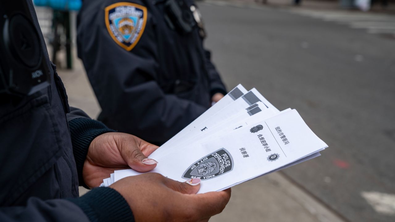 NYPD officers hand out information about hate crimes in Asian communities after mass shootings in Atlanta left 8 dead, including 6 Asian Americans, on March 17, 2021