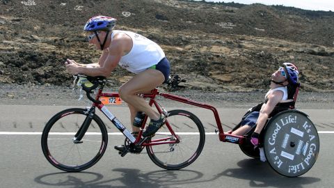 Dick Hoyt and his son, Rick, cross the lava desert during the cycling event of the 27th Iron Man competition in Kailua-Kona, Hawaii, on October18, 2003.