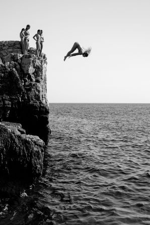 Motion category winner Marijo Maduna, from Croatia, captured the moment a young woman dove from a cliff in front of her friends.