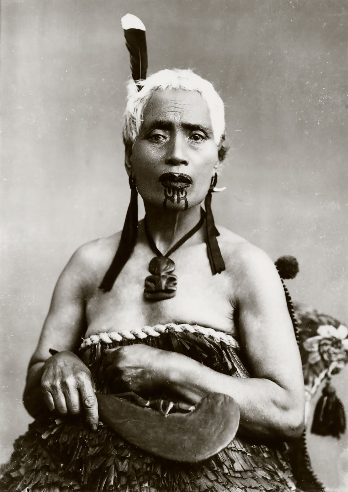 Portrait of a Māori woman with chin moko and feather from the huia bird, ca. 1900s.