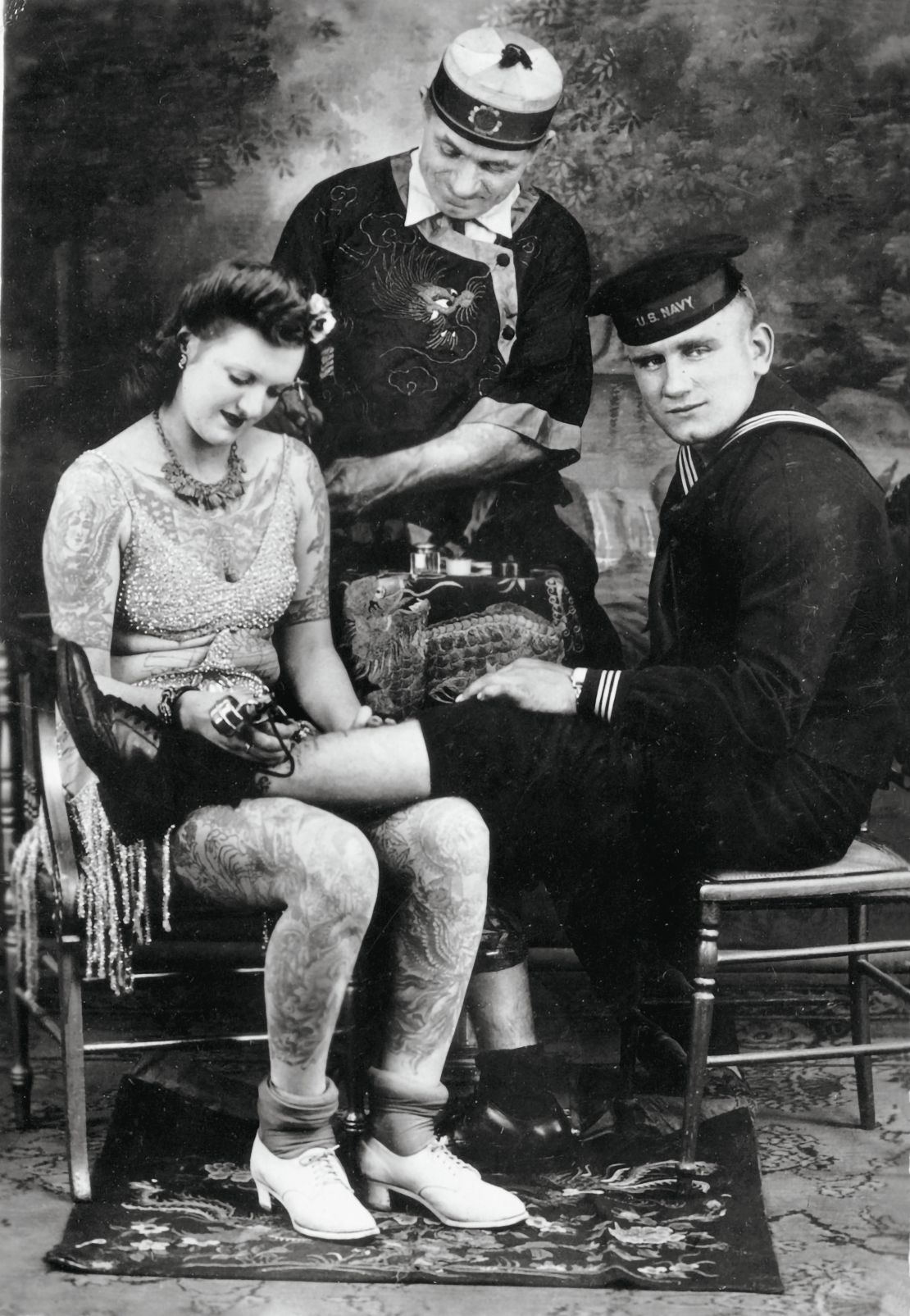 American tattoo artist Charlie Wagner, center, with a tattooed woman and American sailor, ca. 1930s.