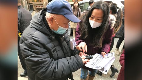A volunteer with Concerned AsAm Citizens of NYC teaching a senior how to use the alarm in New York City's Chinatown.