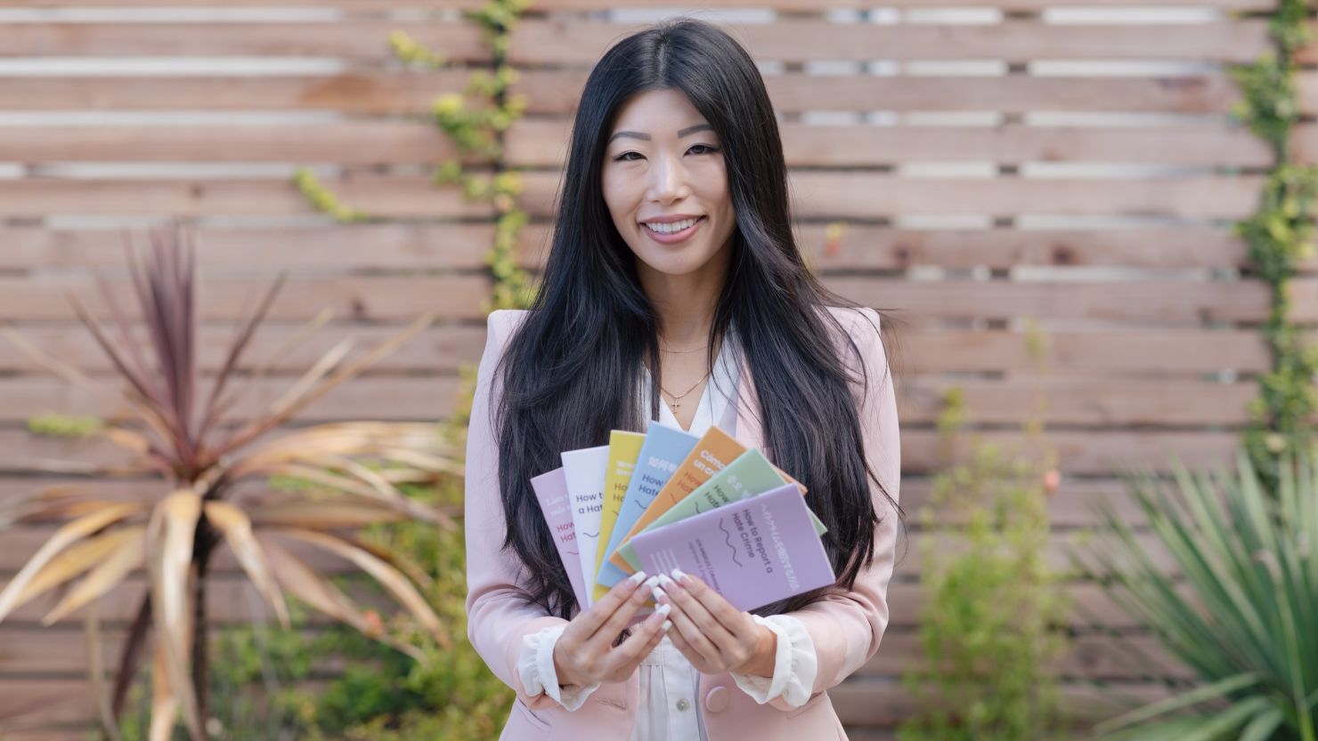 Esther Lim holding her "How to Report a Hate Crime" booklets.