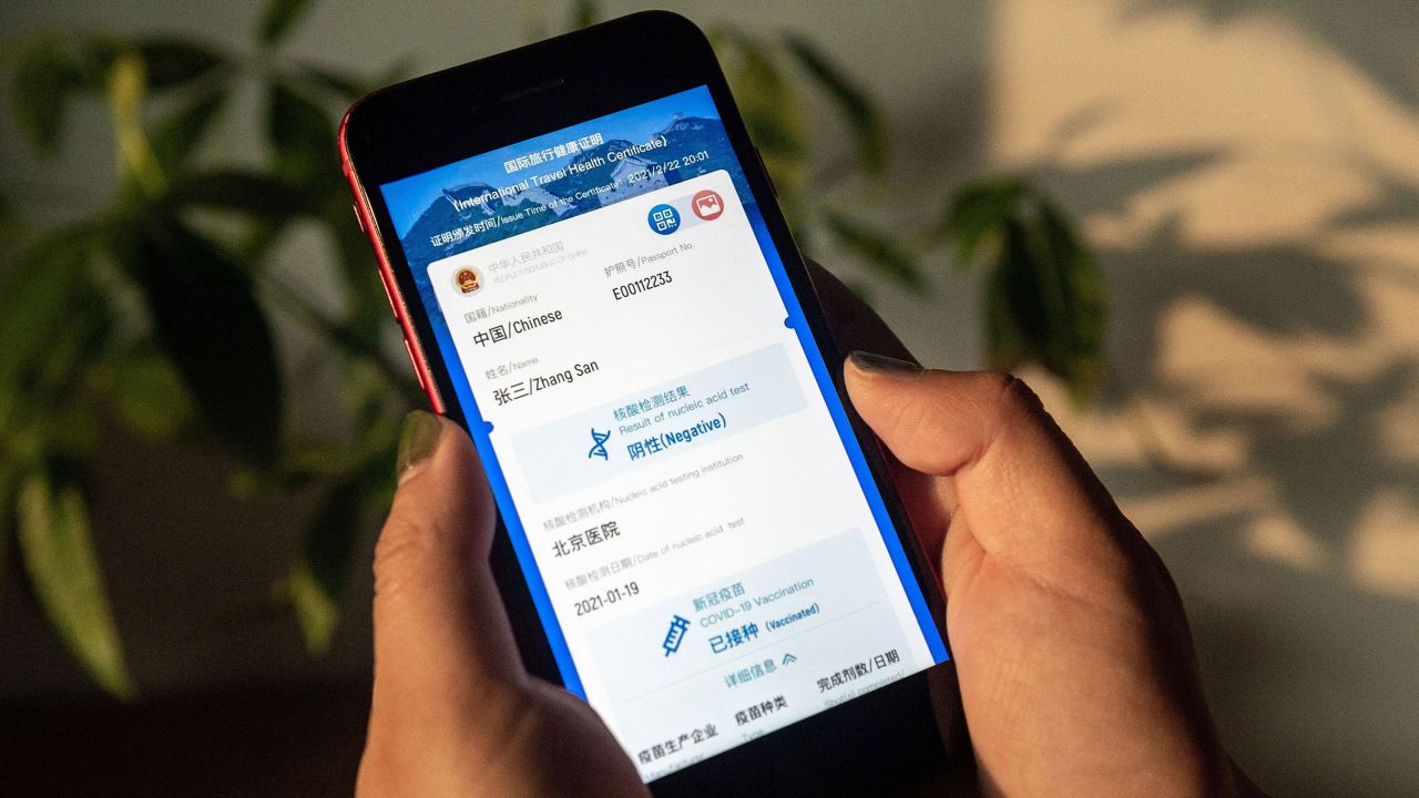 A woman holds a phone displaying a mock-up of Chinas new digital health certificate, the first known implementation of a "virus passport" concept, on March 9, 2021.