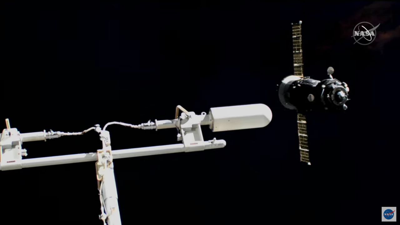 The Soyuz is visible (right) as it flies around the space station.