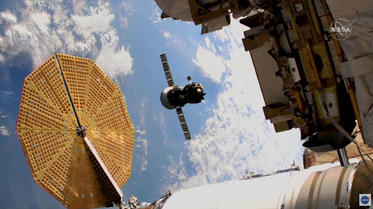 The Soyuz spacecraft can be seen during flight in the middle of this image.