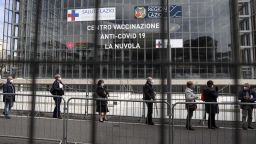 People queue to get the AstraZeneca vaccine shots outside La Nuvola (The Cloud) convention center that was temporarily turned into a COVID-19 vaccination hub, in Rome, Friday, March 19, 2021. Italy's pharmaceutical agency has formally lifted its temporary ban on AstraZeneca vaccinations after the European Medicines Agency ruled the shots were safe and effective. (AP Photo/Gregorio Borgia)