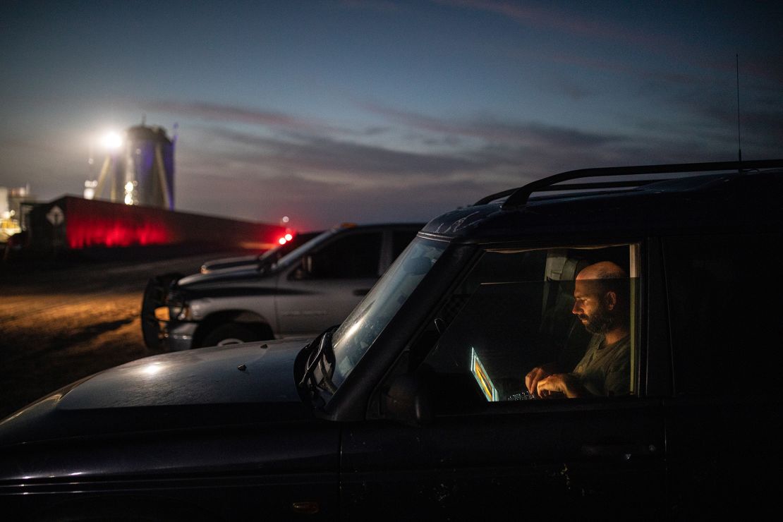 Jack Beyer edits photographs in his vehicle near the SpaceX launch site.