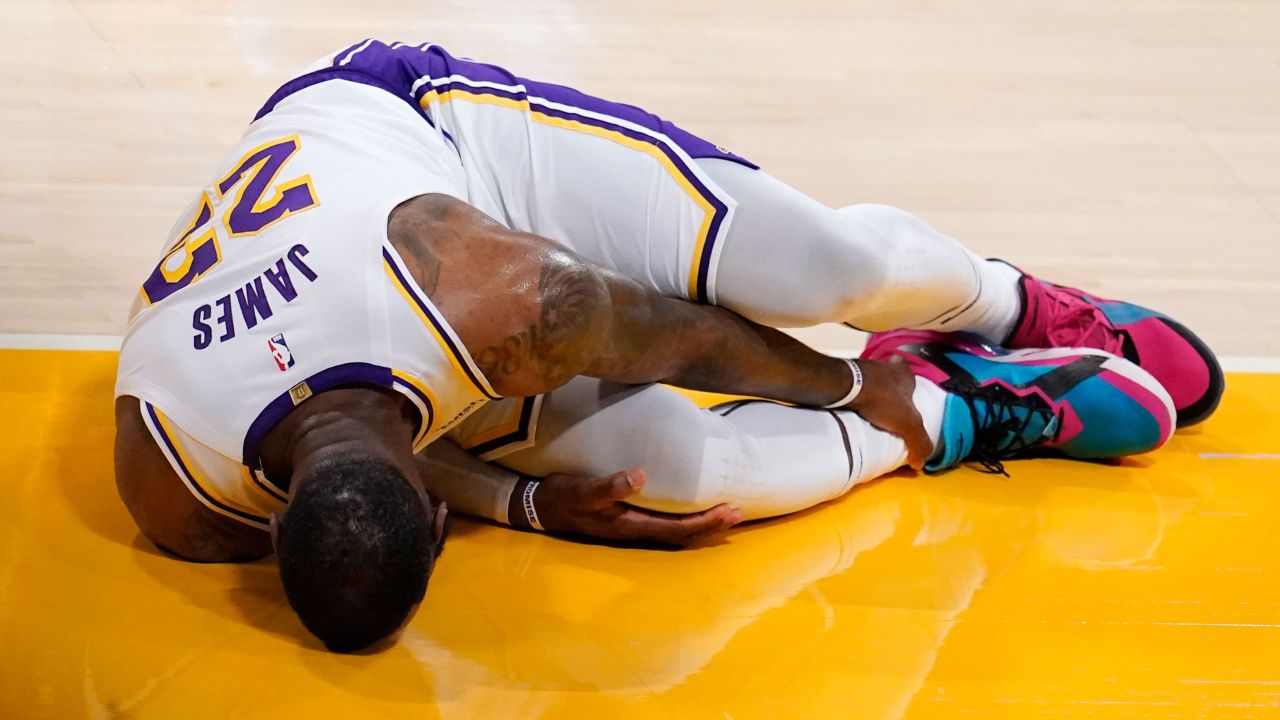 Los Angeles Lakers forward LeBron James holds his ankle after going down with an injury during the first half of a game against the Atlanta Hawks Saturday, March 20, 2021, in Los Angeles. 