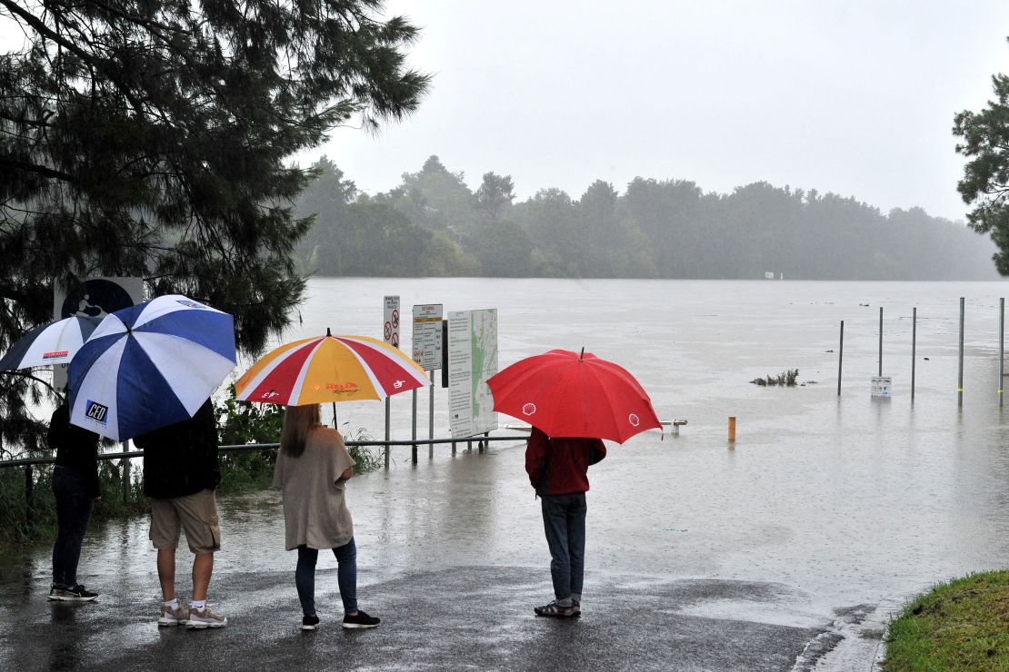 Residents look at the swollen Nepean river during heavy rain in western Sydney on March 20.