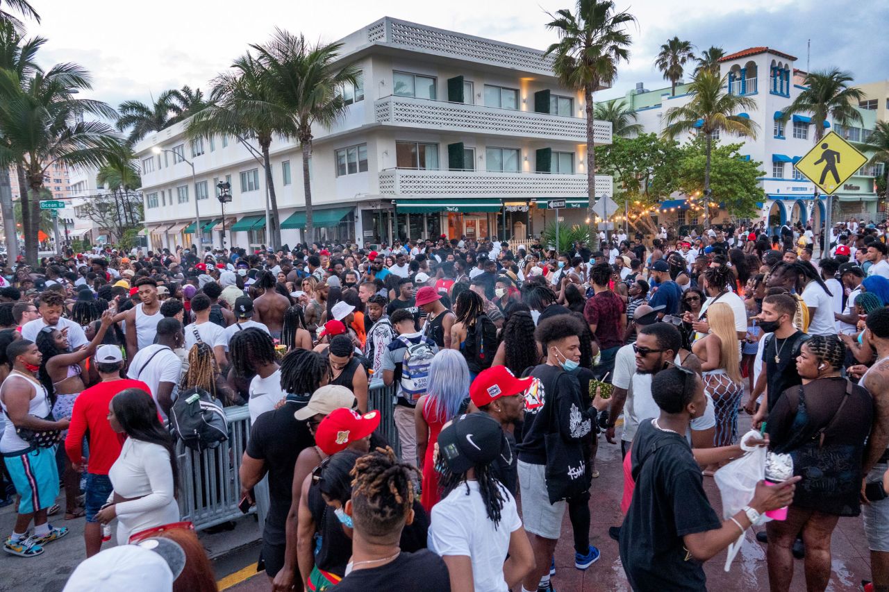 A large crowd of people participate in a party on a walkway near the beach, during spring break in Miami Beach on March 20, 2021