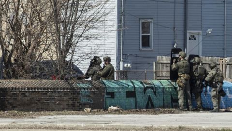 A SWAT team stands by Saturday after five Chicago police officers were shot at, and one of them was struck in the hand.
