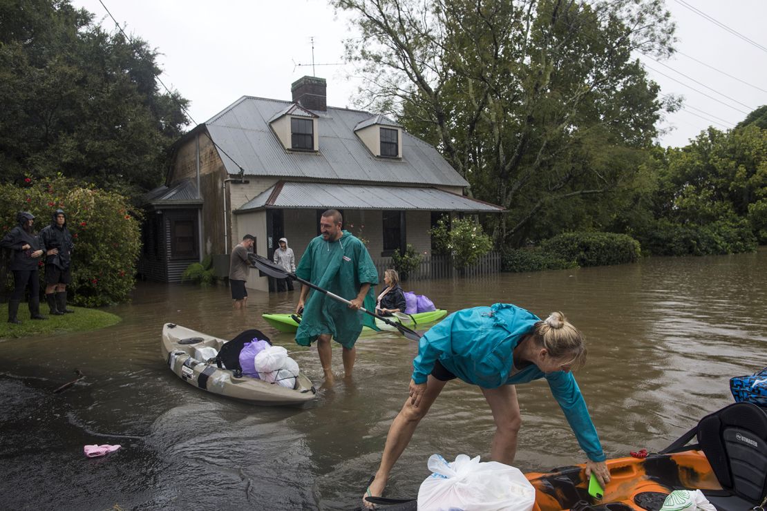 Residents unload household items from kayaks at a street submerged in floodwaters in Windsor, New South Wales, Australia, on March 22.