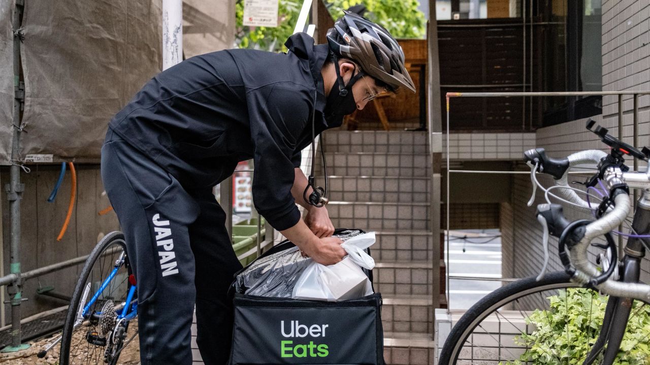 Fencer Ryo Miyake gets a food order from a cafe in Tokyo.