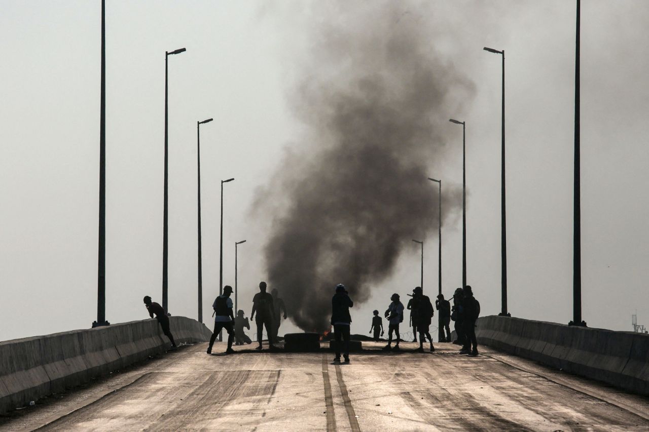 Protesters stand near burning tires in Yangon on March 16.
