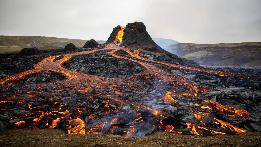 TOPSHOT - Lava flows from the erupting Fagradalsfjall volcano some 40 km west of the Icelandic capital Reykjavik, on March 21, 2021. - Weekend hikers took the opportunity Sunday to inspect the area where a volcano erupted in Iceland on March 19, some 40 kilometres (25 miles) from the capital Reykjavik, the Icelandic Meteorological Office said, as a red cloud lit up the night sky and a no-fly zone was established in the area. (Photo by Jeremie RICHARD / AFP) (Photo by JEREMIE RICHARD/AFP via Getty Images)