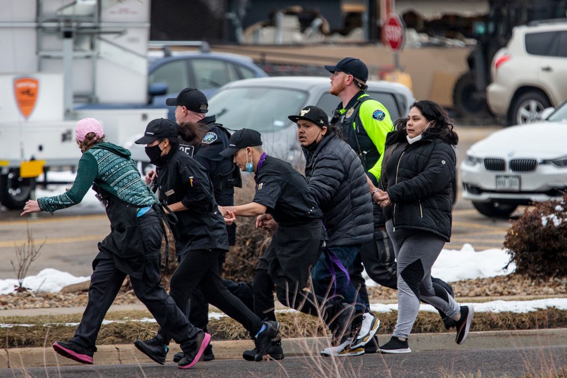 Law enforcement officers escort people out of King Soopers grocery store in southern Boulder.