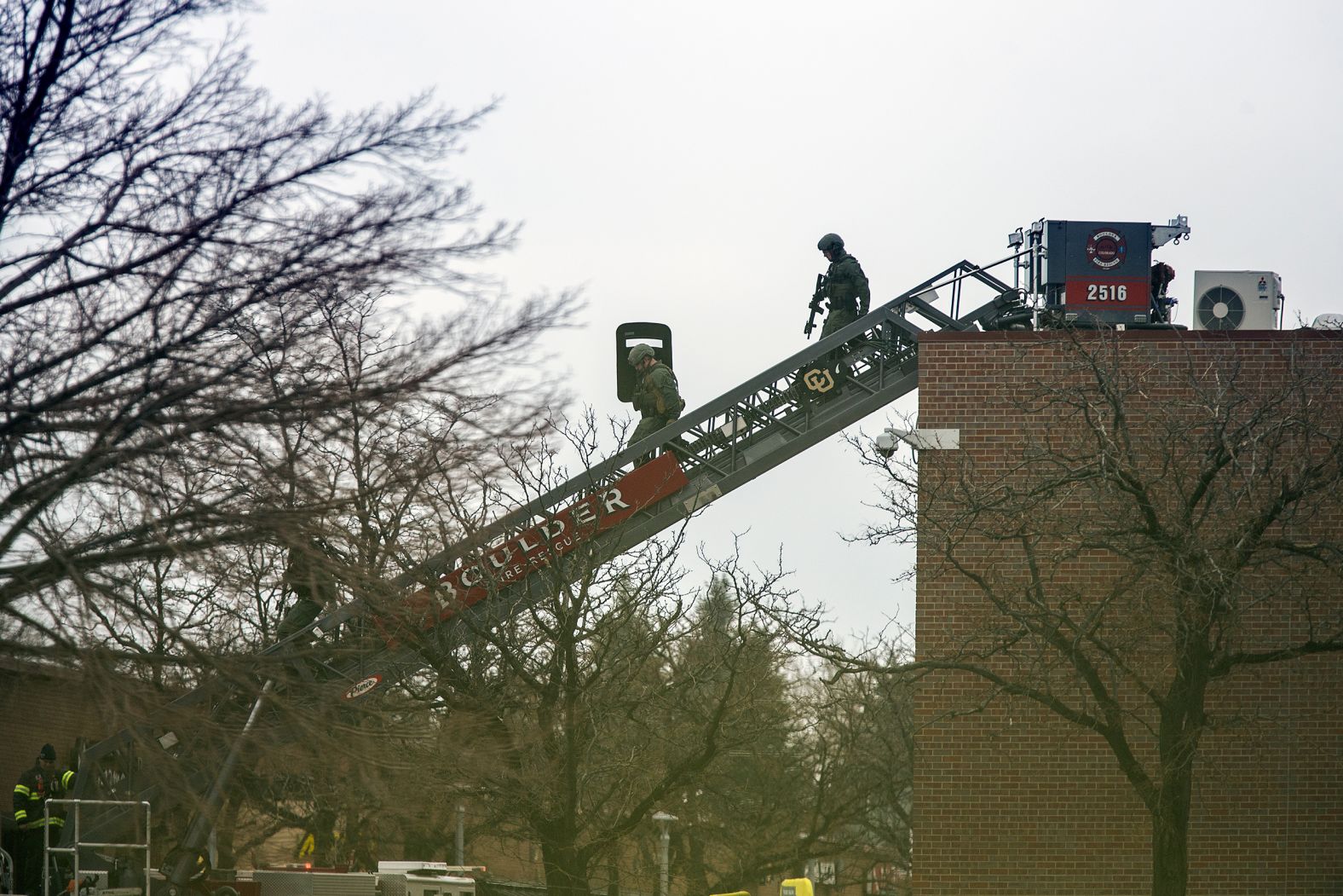 SWAT team members descend from the roof of the store.