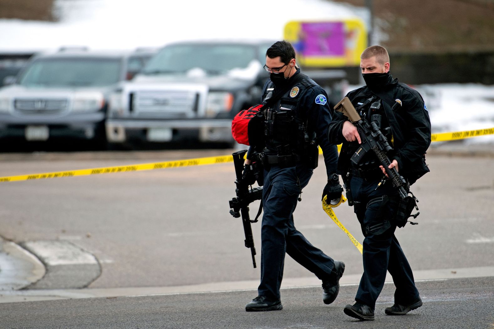 Police officers walk through the parking lot after responding to the scene.