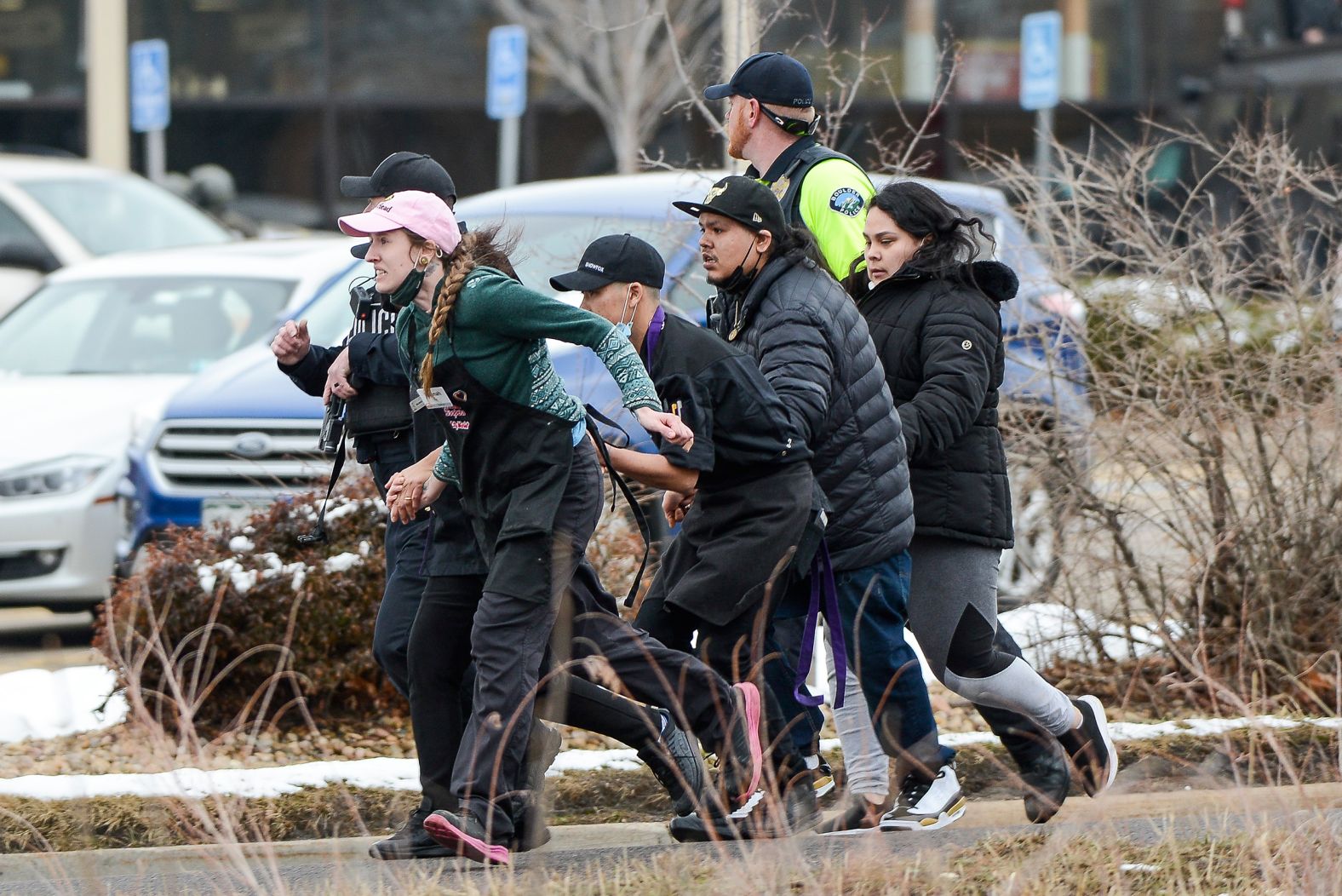 Shoppers are led to safety by police.