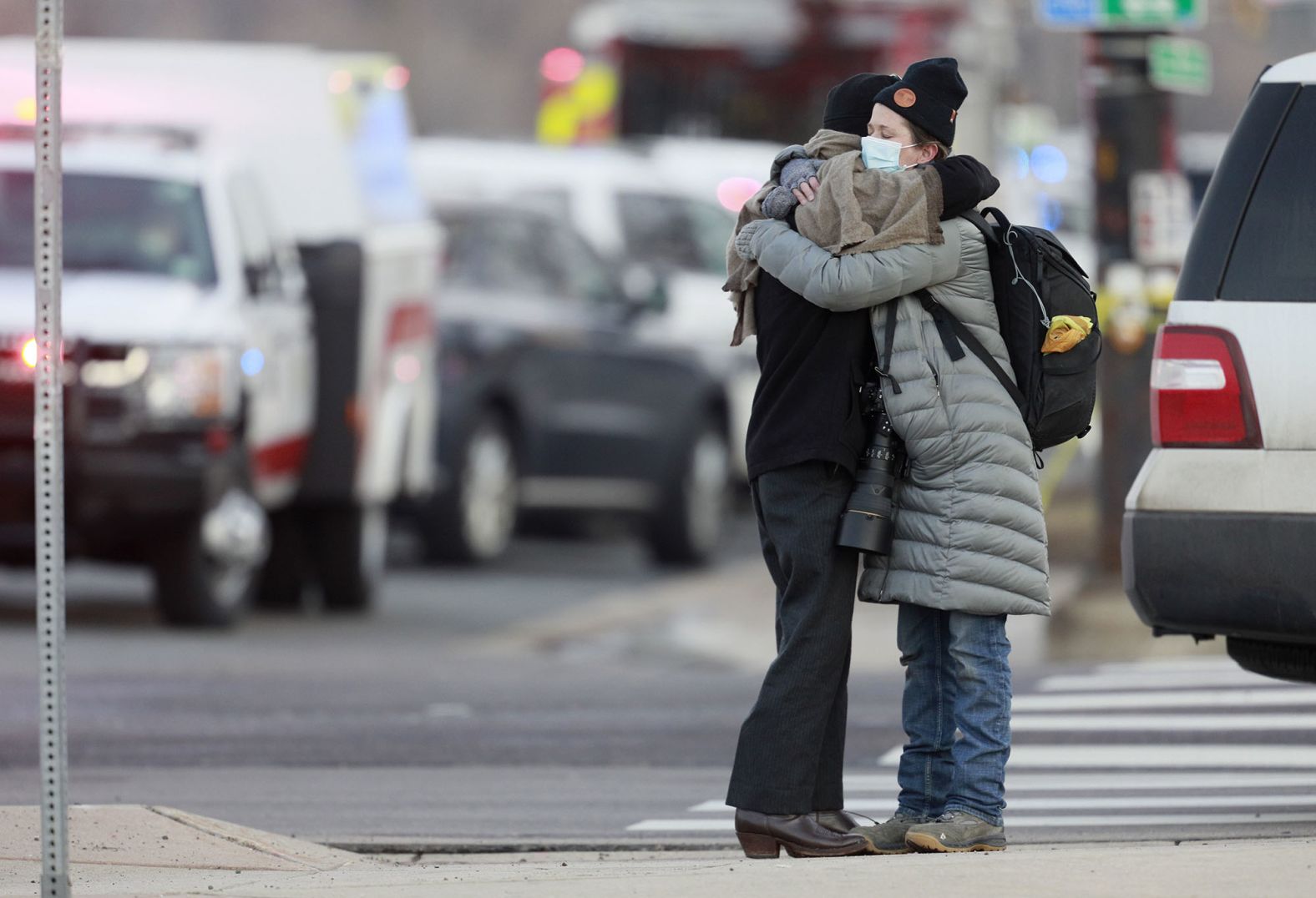 Women hug on the corner of Broadway and Table Mesa Drive.