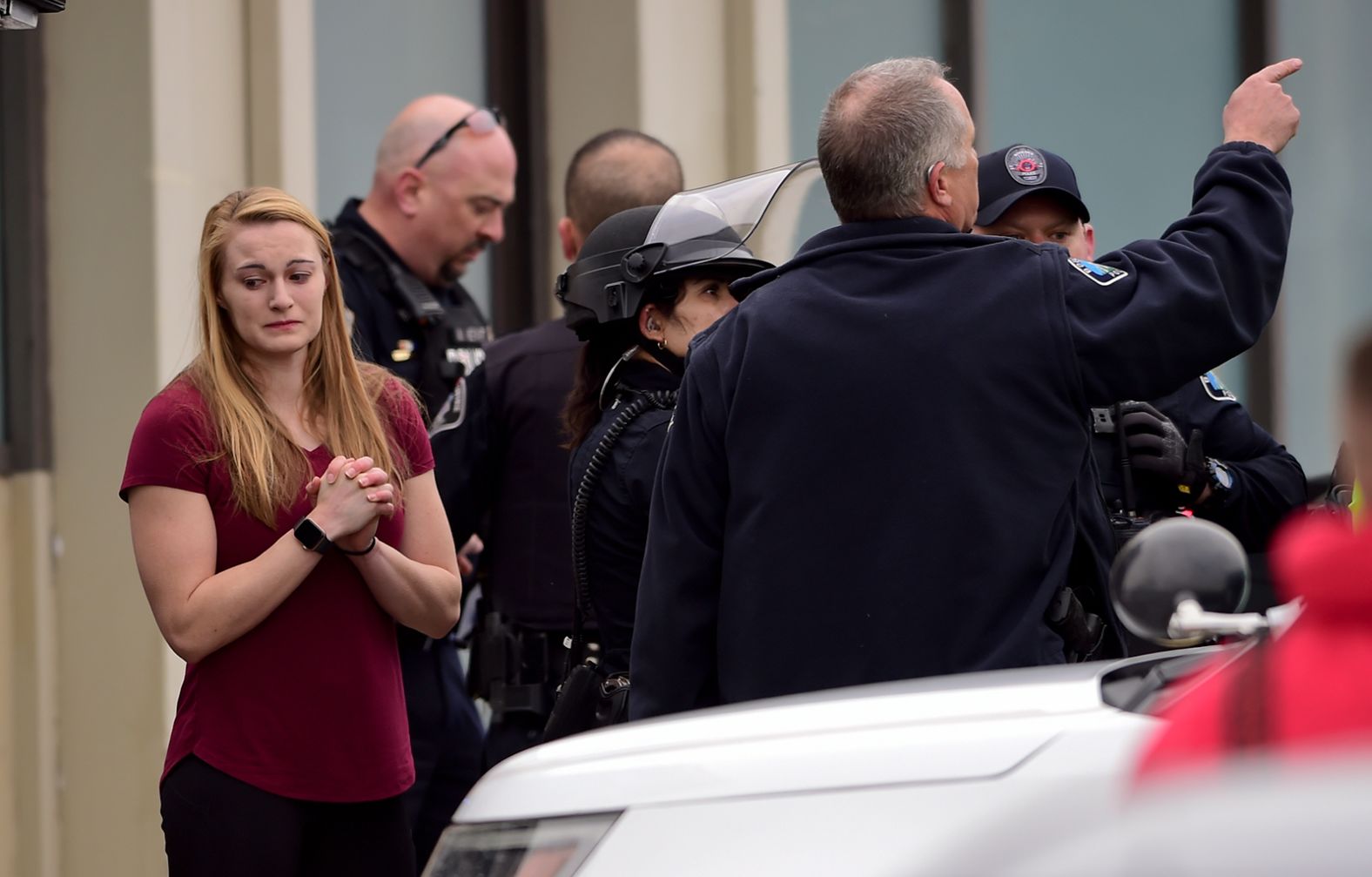 A woman stands with police near the scene.