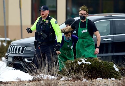 Starbucks employees are helped away from the scene.