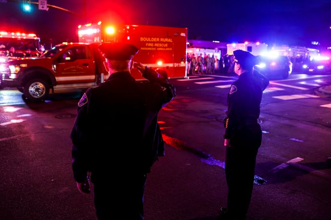 Police officers salute as a fellow officer's body is driven away from the scene on Monday night. Boulder Police Chief Maris Herold said <a href="index.php?page=&url=https%3A%2F%2Fwww.cnn.com%2F2021%2F03%2F23%2Fus%2Fboulder-officer-killed-talley-profile%2Findex.html" target="_blank">Officer Eric Talley,</a> 51, had been with the department since 2010. He was one of the first officers at the scene, she said.