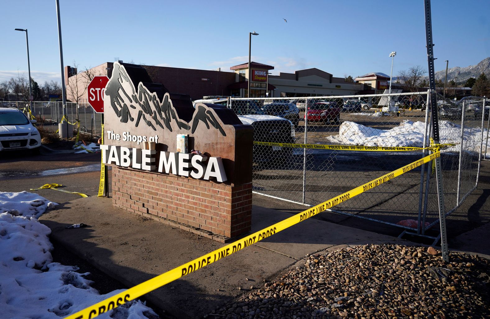 Caution tape stretches along a makeshift fence Tuesday that was put up around the store's parking lot.