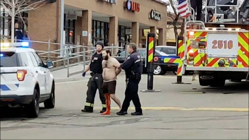 Police lead a handcuffed man, bleeding from his leg and dressed only in underwear, away from the scene of the shooting on Monday. The handcuffed man is shooting suspect Ahmad Al Aliwi Alissa, <a href="index.php?page=&url=https%3A%2F%2Fwww.cnn.com%2Fus%2Flive-news%2Fboulder-colorado-shooting-3-23-21%2Fh_4b8ba302da2648a8ab2f2640ae52a0f8" target="_blank">his brother confirmed to CNN.</a> Alissa, 21, is a resident of Arvada, Colorado, a suburb of Denver.