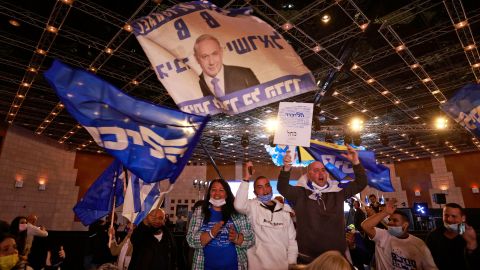Likud supporters wave flags bearing the party name and the face of its leader, Benjamin Netanyahu, at its campaign headquarters in Jerusalem on March 23.