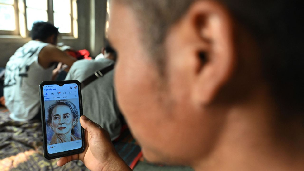 A Myanmarese policeman, who fled Myanmar and crossed illegally to India, looks at a picture of detained Myanmar civilian leader Aung San Suu Kyi on his social media at an undisclosed location in India's northeastern state of Mizoram on March 13, 2021. - Scores of Myanmar policemen and their families have now fled to India, security officials said on March 12, with one officer telling AFP that the authorities are "beating and torturing" protestors. (Photo by Sajjad HUSSAIN / AFP) (Photo by SAJJAD HUSSAIN/AFP via Getty Images)