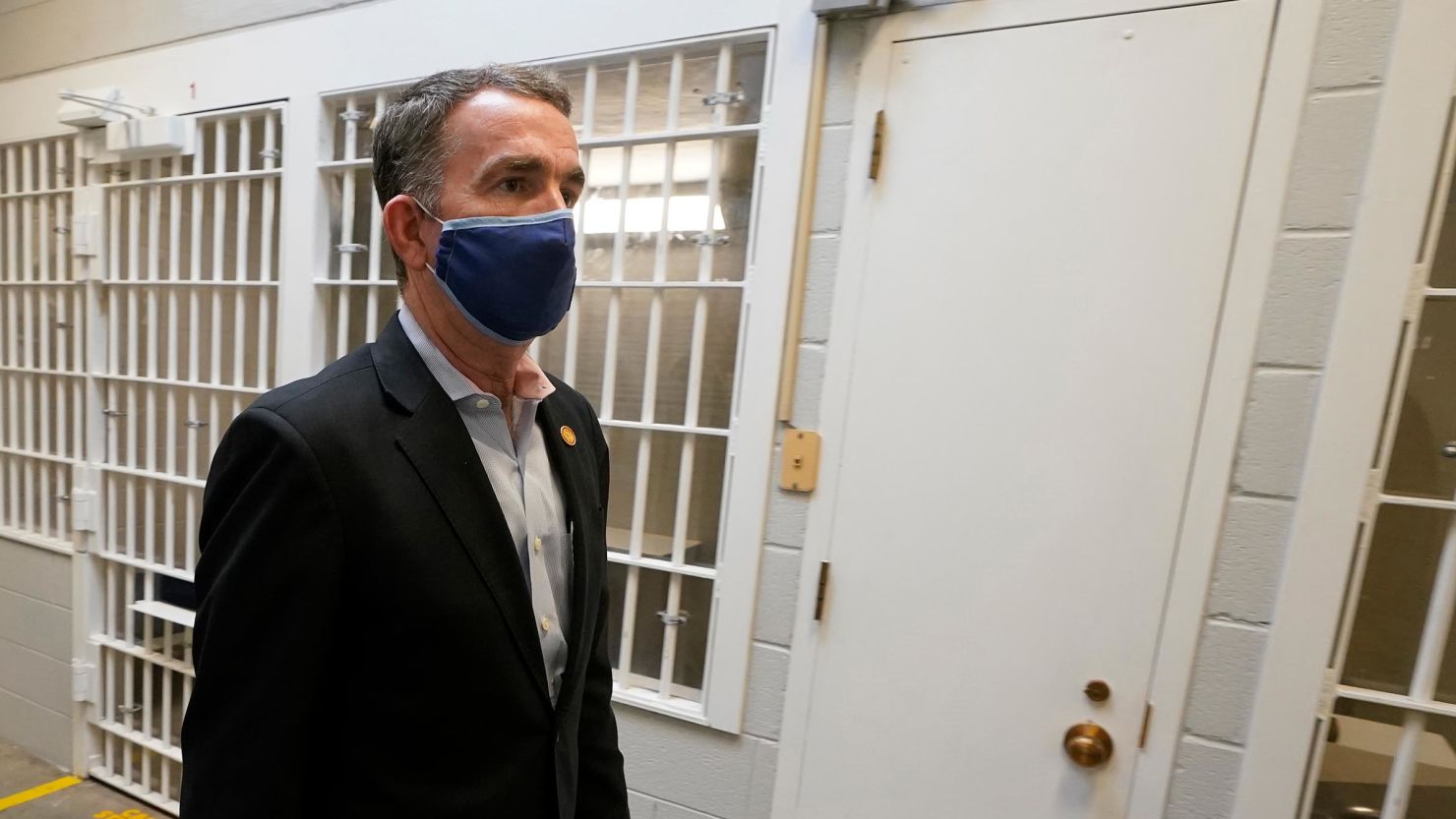 Gov. Ralph Northam walks past the holding cells next to the death chamber during a tour at the Greensville Correctional Center prior to signing a bill abolishing the state's death penalty in Jarratt, Virginia, on Wednesday, March 24. 