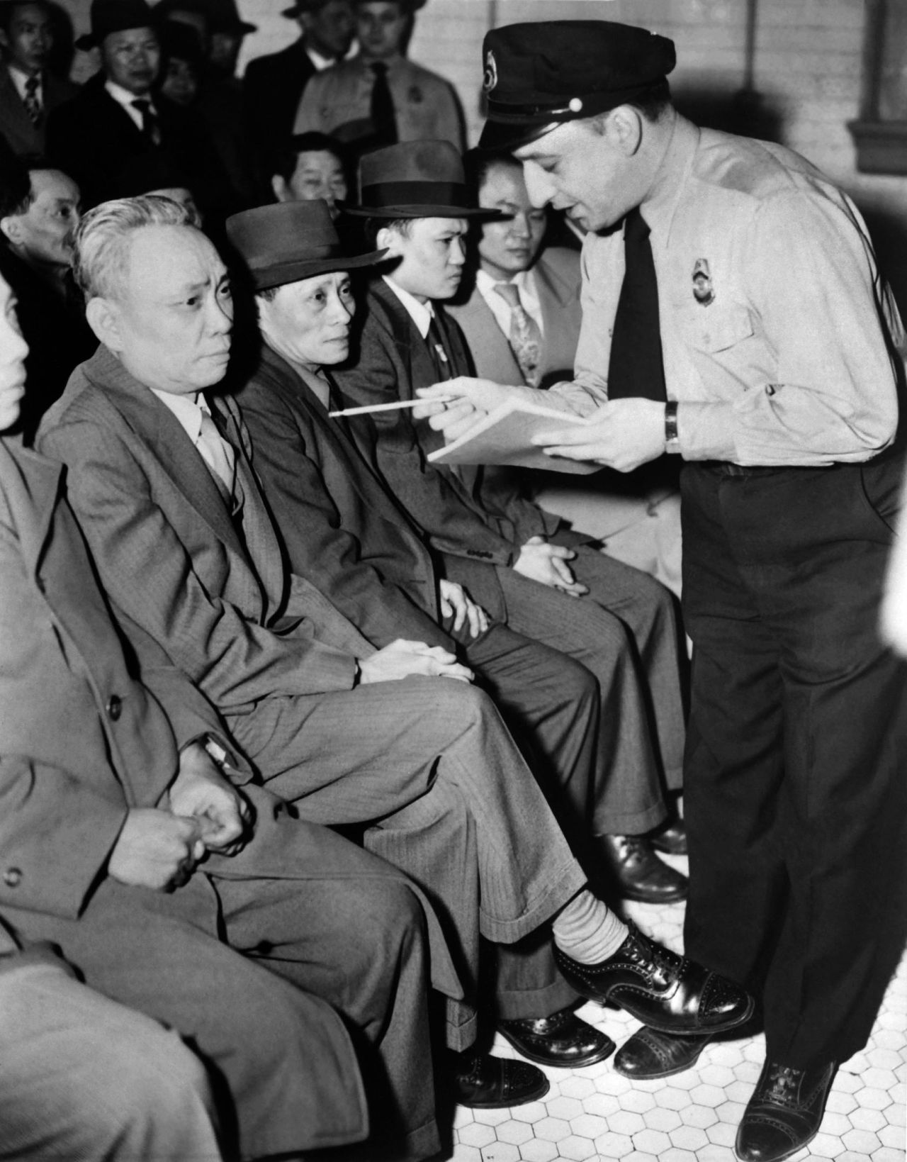 Asian men being interrogated by an immigration officer on February 2, 1951 in Brooklyn, New York.