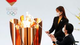 Actor Satomi Ishihara (L) and Paralympian Aki Taguchi (R) light the celebration cauldron on the first day of the Tokyo 2020 Olympic torch relay in Naraha, Fukushima prefecture on March 25, 2021. (Photo by KIM KYUNG-HOON / POOL / AFP) (Photo by KIM KYUNG-HOON/POOL/AFP via Getty Images)