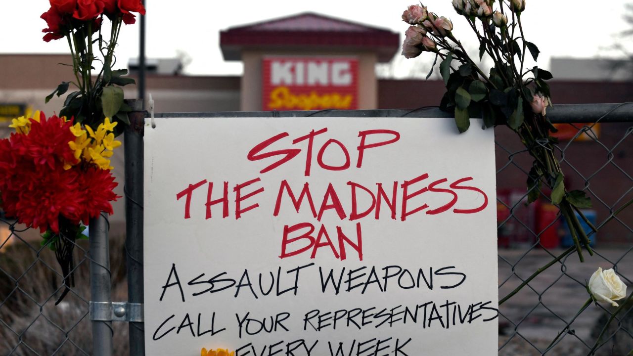 A sign hangs from the perimeter fence outside the King Soopers grocery store in Boulder, Colorado, on March 24.