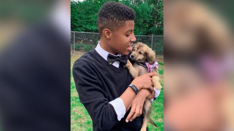 Darius Brown with a shelter dog that's wearing one of his bow ties.