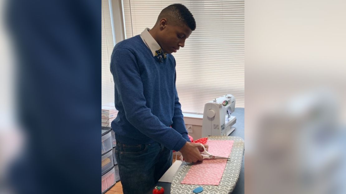 Darius Brown cutting the fabric for a bow tie.