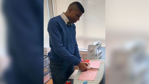 Darius Brown cutting the fabric for a bow tie.