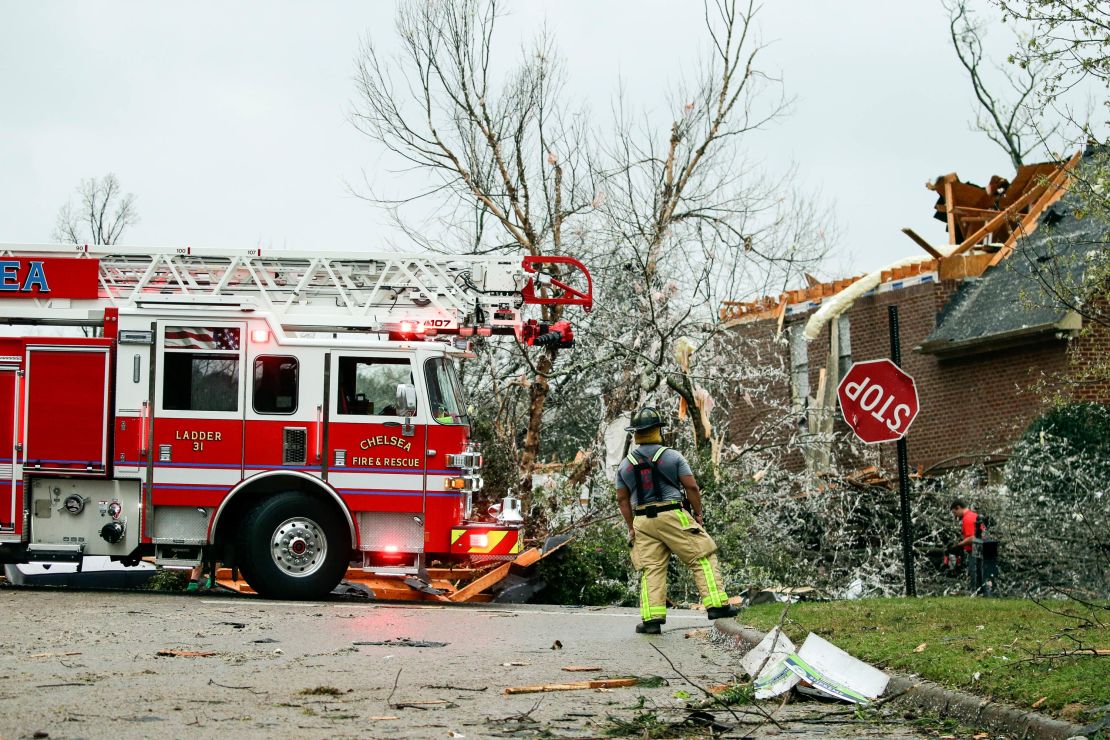 A firefighter surveys damage after a tornado touched down in the Eagle Point community south of Birmingham on Thursday, March 25.