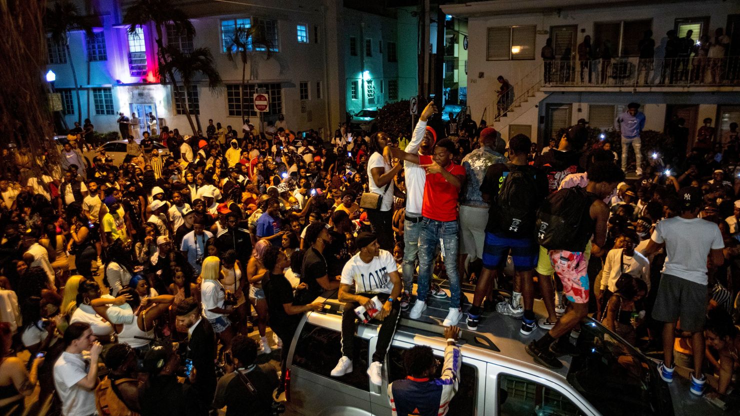 Crowds defiantly gather in the street while a speaker blasts music an hour past curfew in Miami Beach, Florida, on March 21, 2021. 