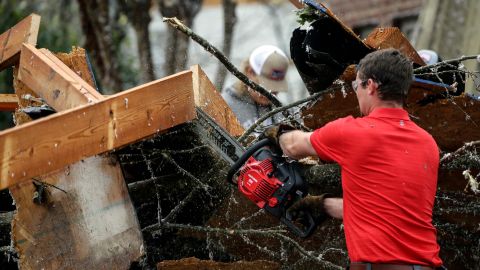 Eagle Point residents cut away debris after a tornado touched down Thursday.