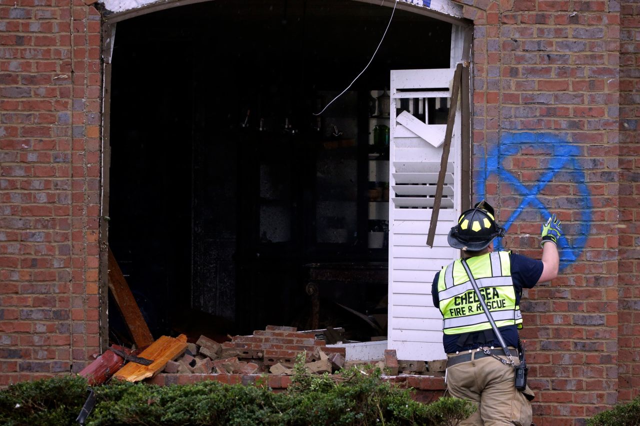 A firefighter marks an Eagle Point house after surveying the damage Thursday.
