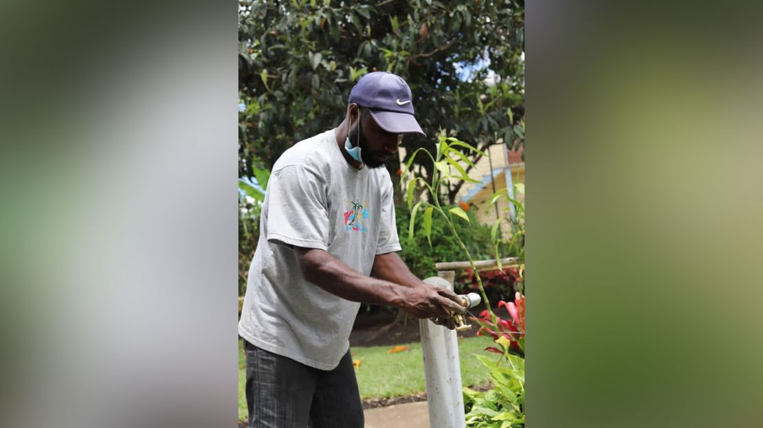 A contractor for CARE International fits taps onto new water pipes as part of the NGO's efforts to construct hand-washing facilities.