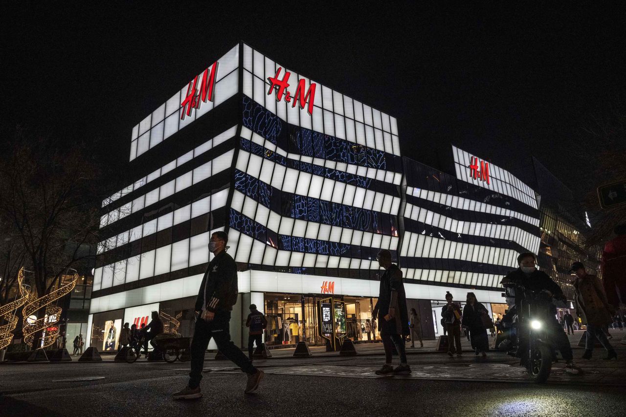 People walk by the flagship store of clothing brand H&M at a shopping area on March 25, 2021 in Beijing, China.