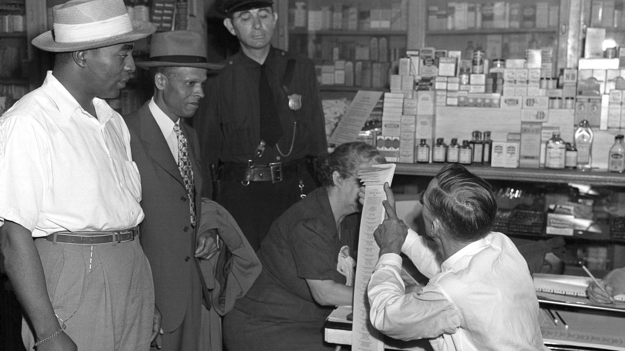An election official tells World War II veteran Lewis K. McGuire, left, and physician S. M. Lewis, right -- who tried to vote in 1945 in Atlanta -- that the primary is for White people only.