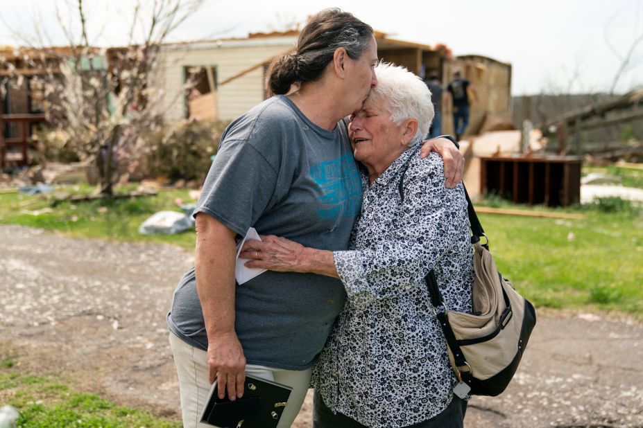 Mary Umetsu, left, embraces her friend Carol Cunningham outside Umetsu's damaged home in Ohatchee, Alabama, on Friday, March 26.