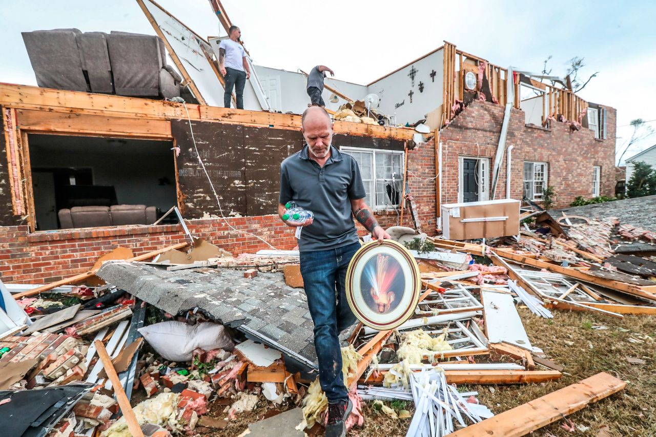 A man moves personal items from a damaged home in Newnan, Georgia.